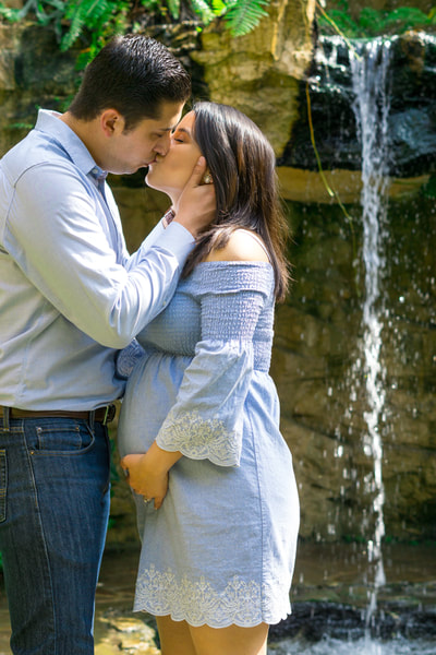 couple kissing with waterfall behind them