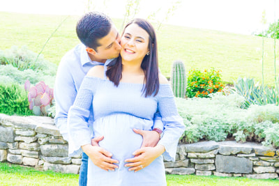 couple kissing holding baby bump