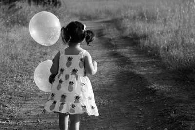 girl on path with balloons