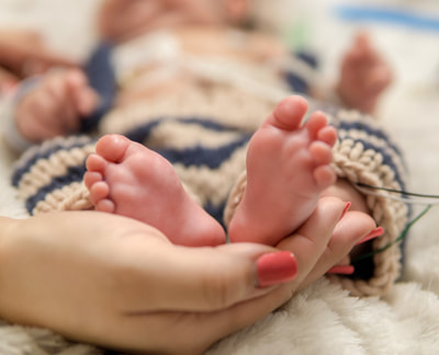 mother's hands cupping baby's feet