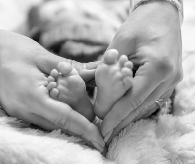 mother's hands around baby's feet