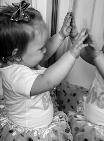 baby looking at reflection in mirror
