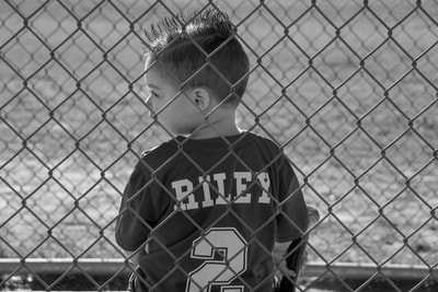 Riley in the dugout from behind with jersey.